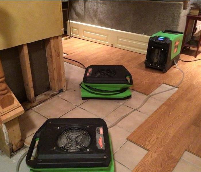 3 SERVPRO green pieces of drying equipment set up near the affected area and on the hardwood floors.