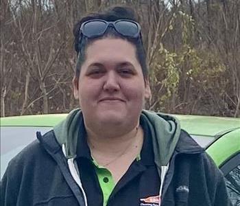 A smiling female employee in a black SERVPRO shirt