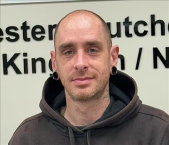 A photo of a smiling male employee wearing a black SERVPRO sweatshirt.